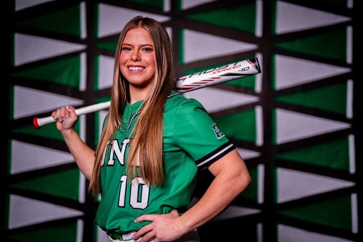 Riley McNemar #10 in green UNT uniform with bat